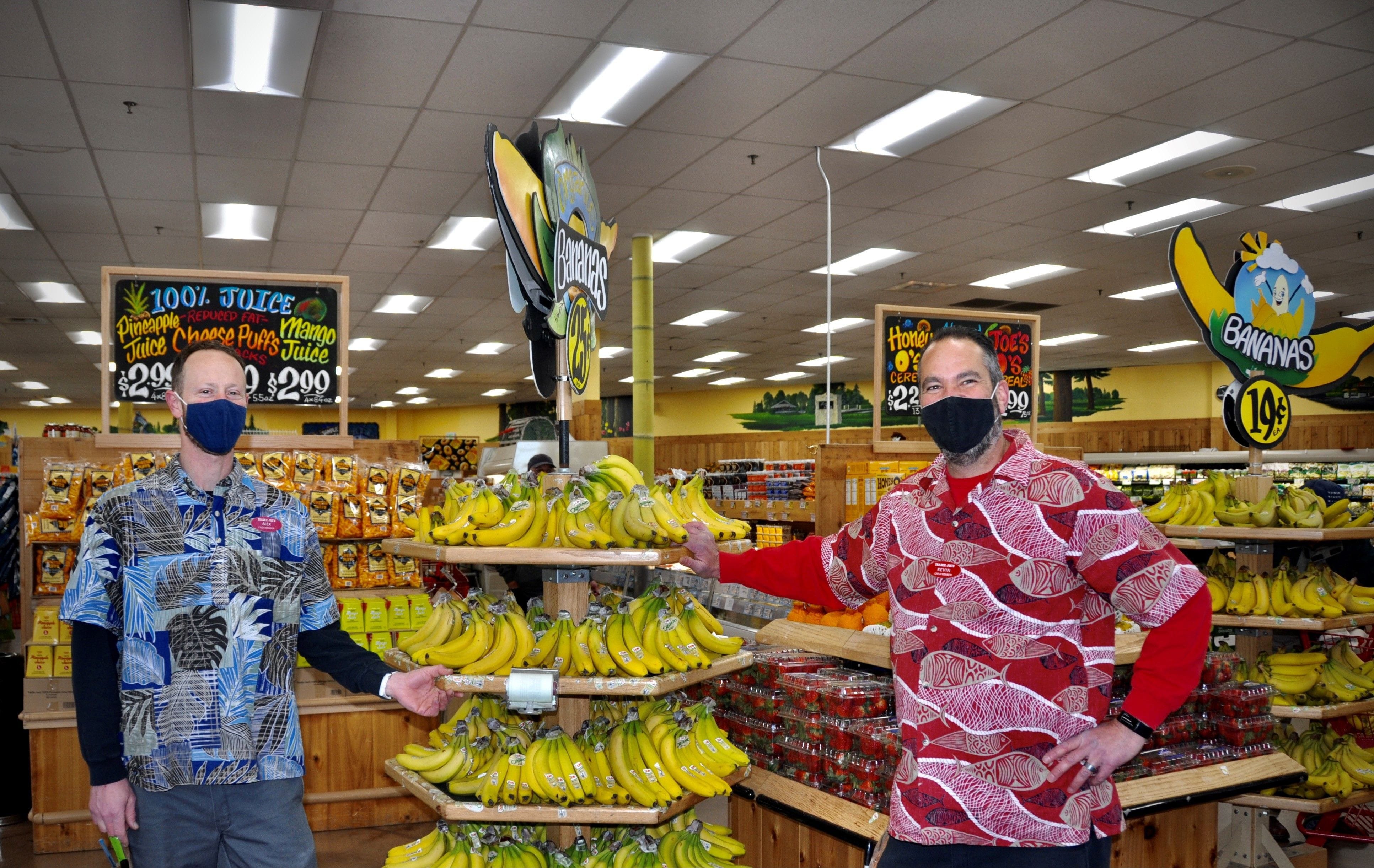 Trader Joe's Crew Members standing by the banana display.