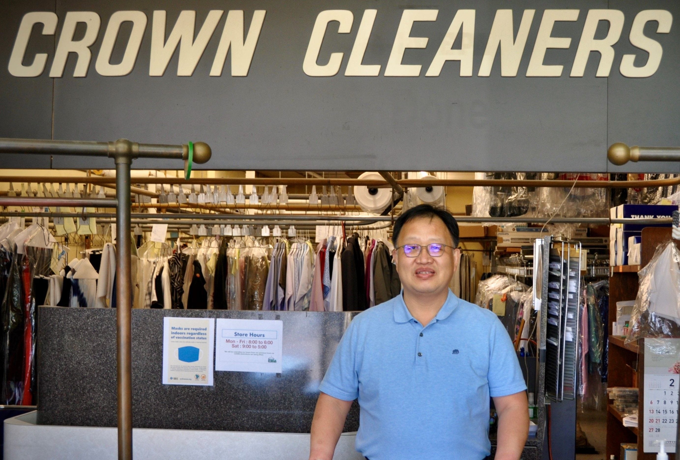 The owner of Crown Cleaners standing at the counter.