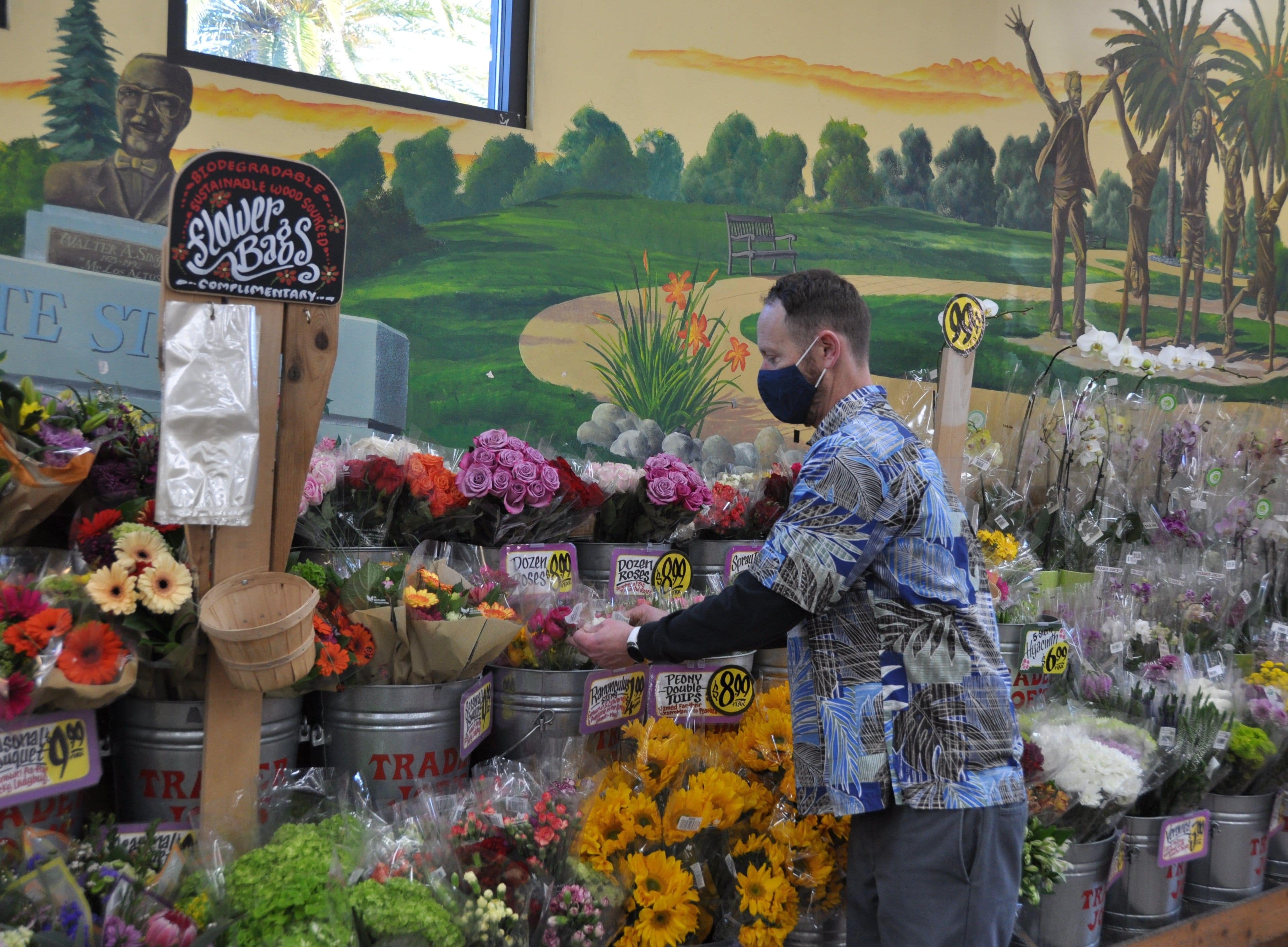 Trader Joe's Crew Member arranging the cut flower display.